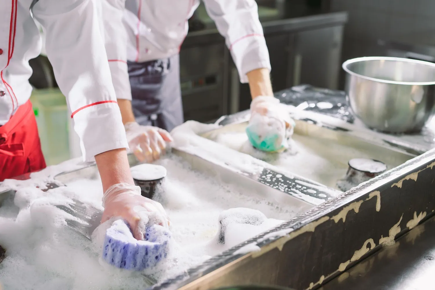 Staff cleaning kitchen preparing for busy day